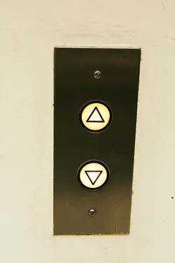Botões de subir e descer de um elevador.